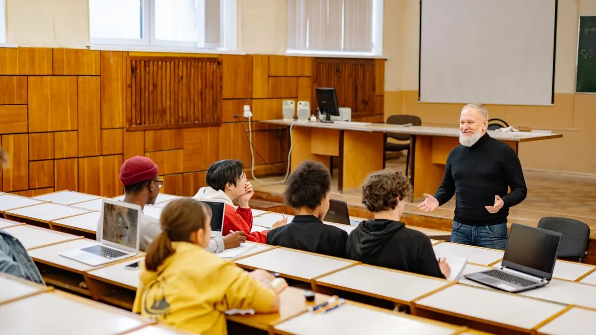 Lektor mluví ke studentům s notebooky v sále