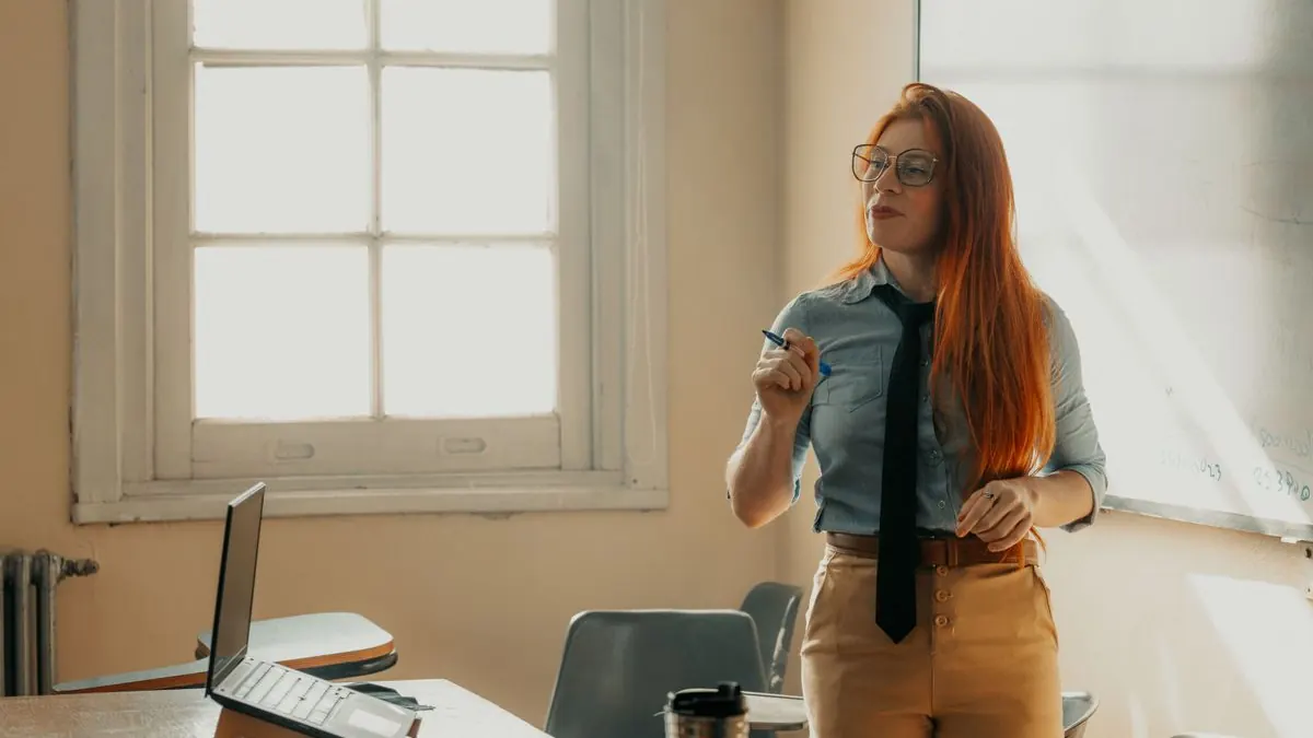 Lektorka přednáší ve světlé učebně s laptopem