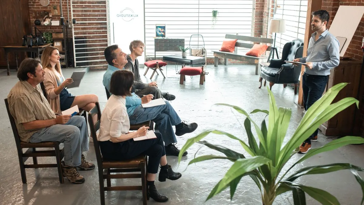 Skupina dospělých diskutuje v kruhu na workshopu
