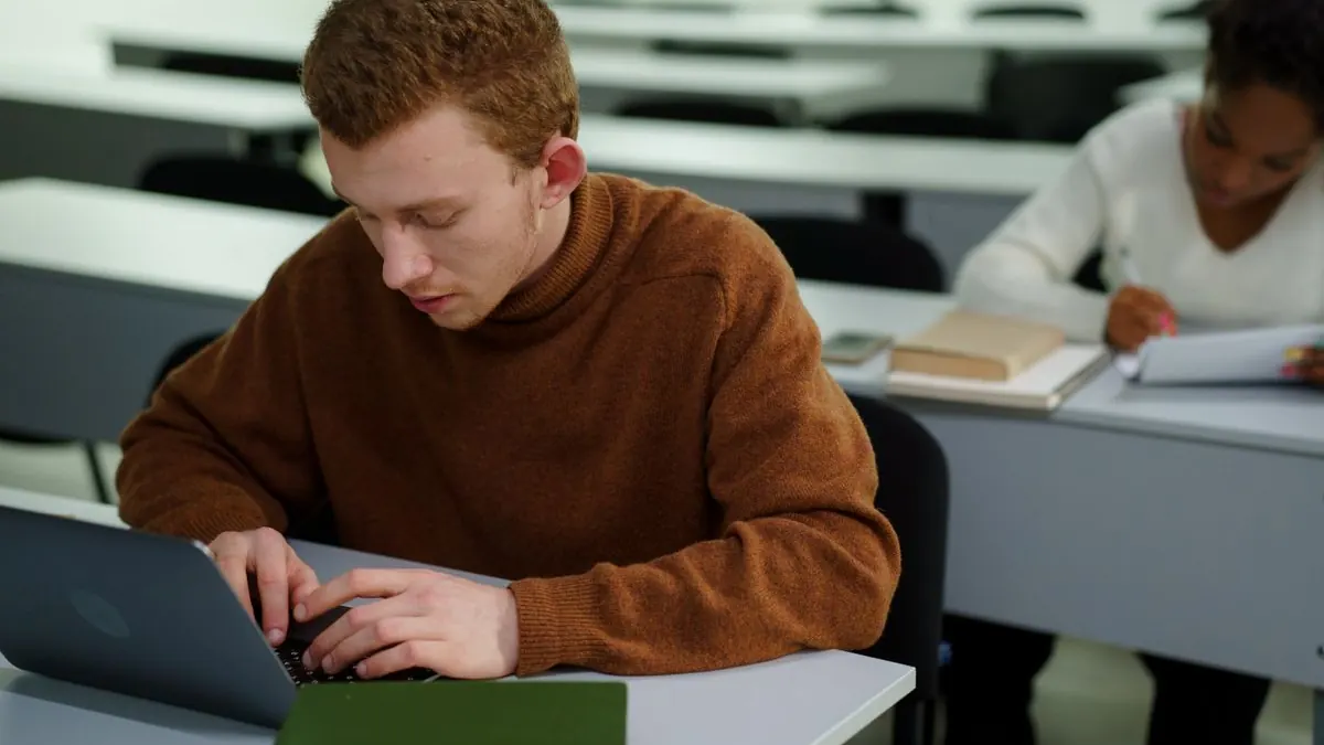 Student pracuje na notebooku ve třídě