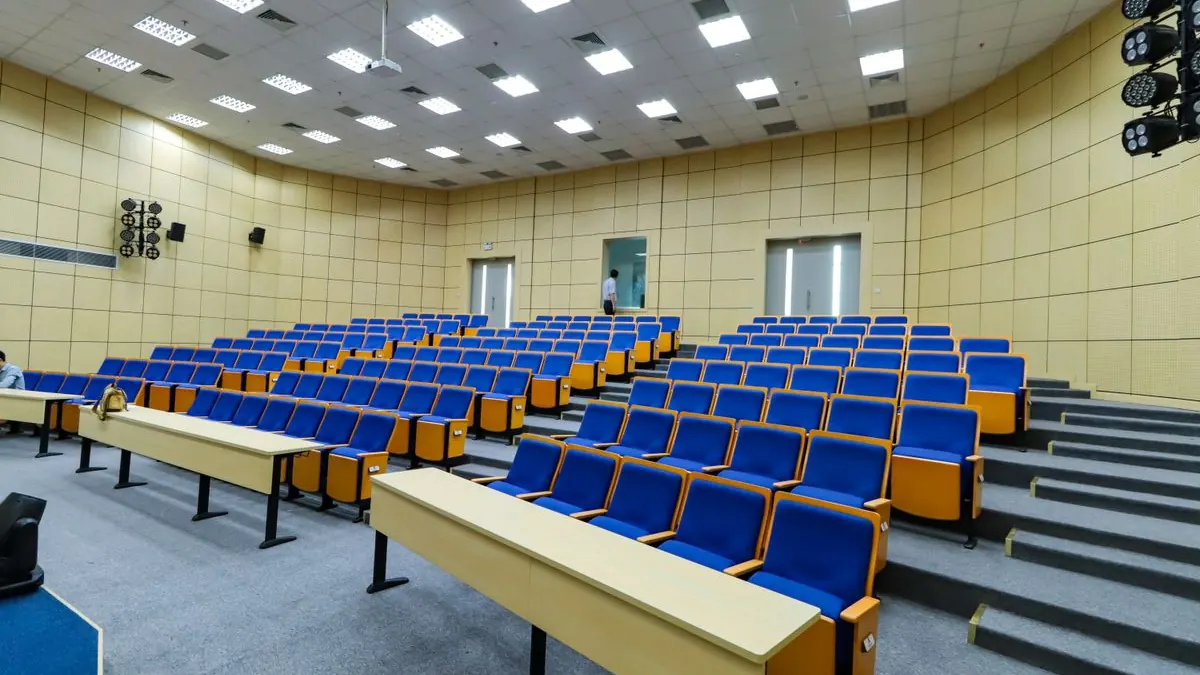 Prázdná přednášková aula s modrými sedadly