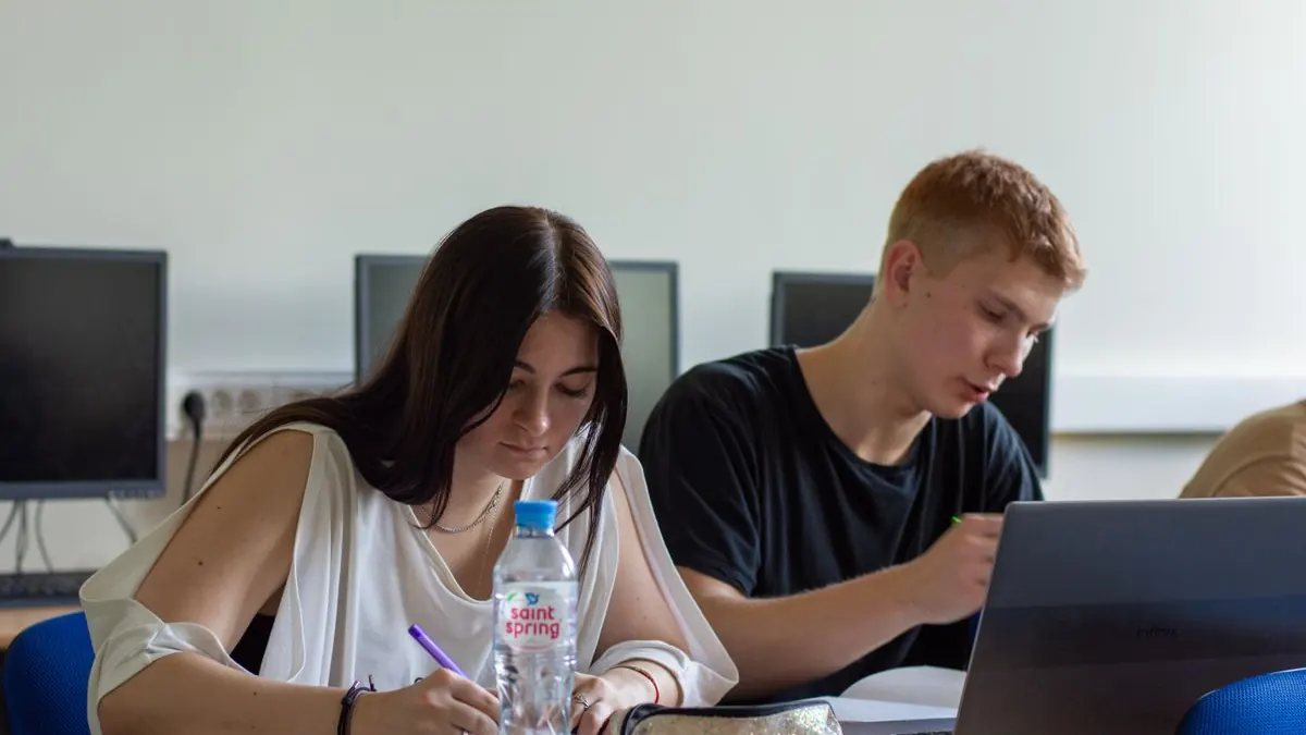 Dva studenti pracují s notebooky v učebně