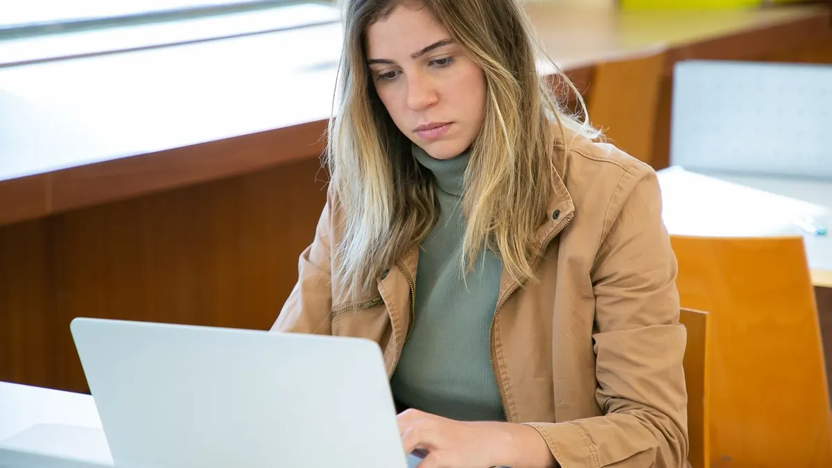 Studentka pracuje s notebookem v knihovně