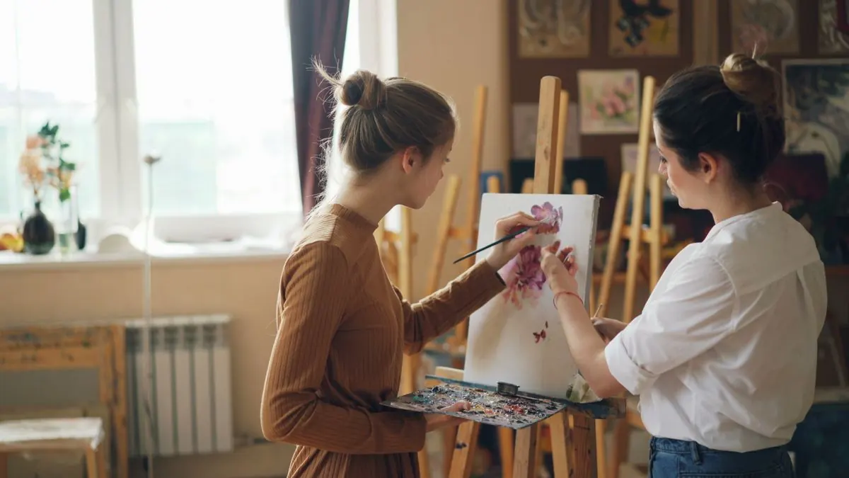 Ženy malují květiny u okna v ateliéru
