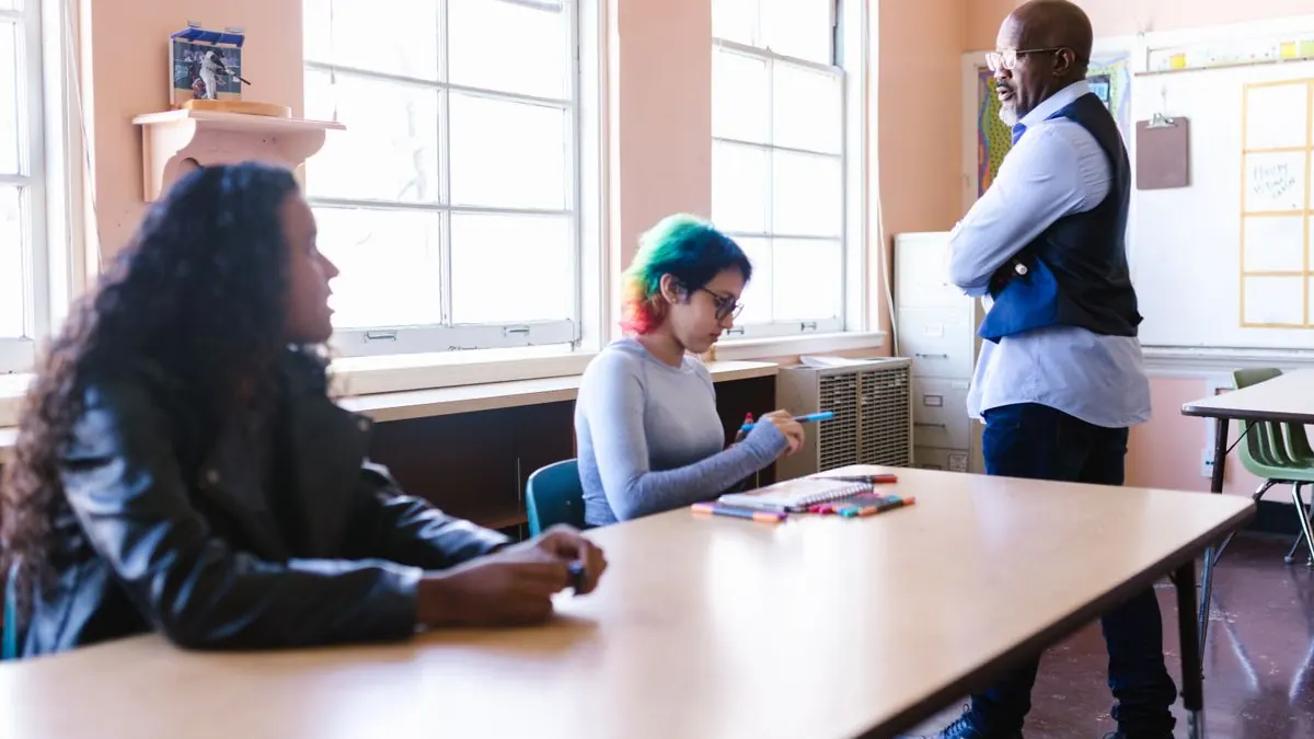 Studentka diskutuje s vyučujícím v učebně